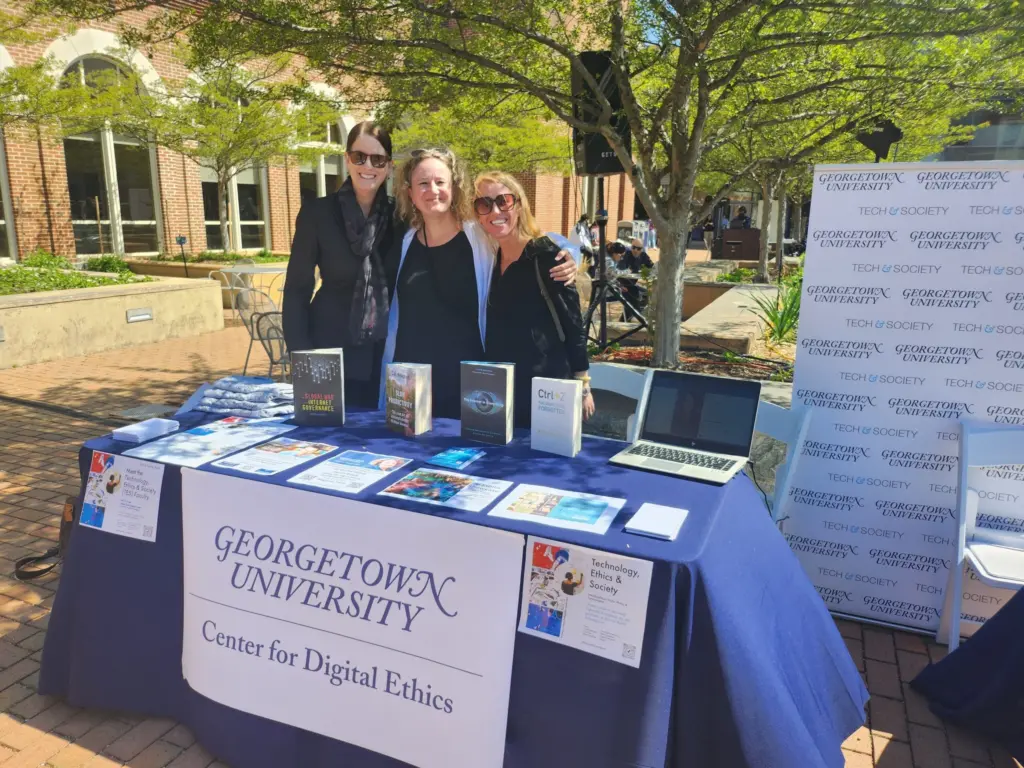 Laura DeNardis with danah boyd and Meg Leta Jones in front of the CDE table